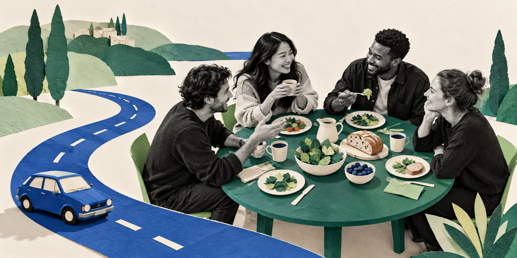 Coworkers share dinner at a round table, with a winding road and a small car behind them.